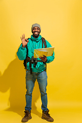 Image showing Full length portrait of a cheerful young african tourist guy isolated on yellow background