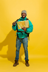 Image showing Full length portrait of a cheerful young african tourist guy isolated on yellow background