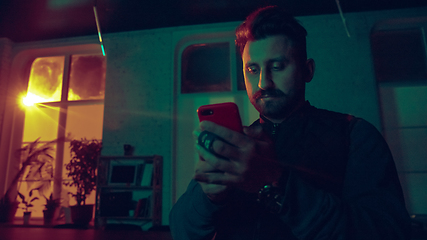 Image showing Cinematic portrait of handsome man in neon lighted interior