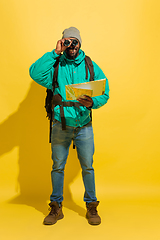 Image showing Full length portrait of a cheerful young african tourist guy isolated on yellow background