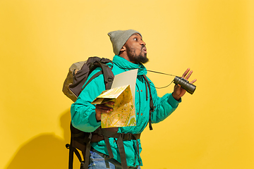 Image showing Full length portrait of a cheerful young african tourist guy isolated on yellow background