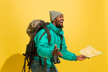 Image showing Full length portrait of a cheerful young african tourist guy isolated on yellow background