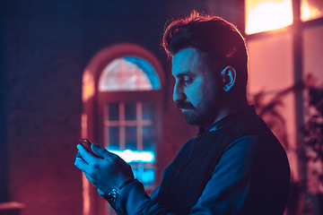 Image showing Cinematic portrait of handsome man in neon lighted interior