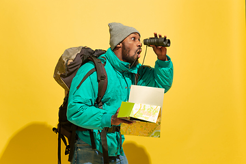 Image showing Full length portrait of a cheerful young african tourist guy isolated on yellow background