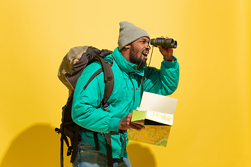 Image showing Full length portrait of a cheerful young african tourist guy isolated on yellow background