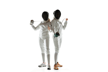 Image showing Teen girls in fencing costumes with swords in hands isolated on white background