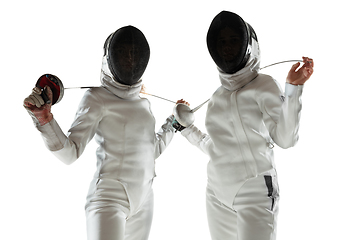 Image showing Teen girls in fencing costumes with swords in hands isolated on white background