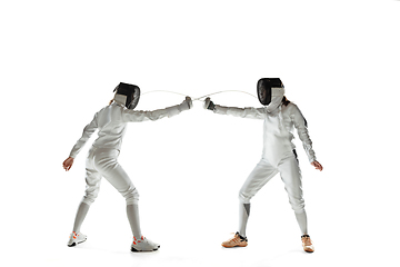 Image showing Teen girls in fencing costumes with swords in hands isolated on white background