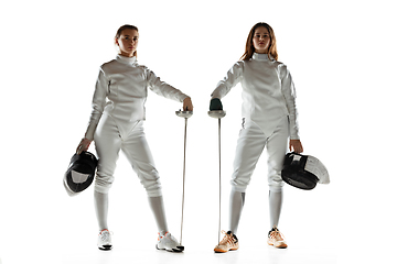 Image showing Teen girls in fencing costumes with swords in hands isolated on white background