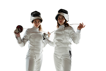 Image showing Teen girls in fencing costumes with swords in hands isolated on white background