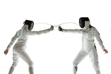 Image showing Teen girls in fencing costumes with swords in hands isolated on white background