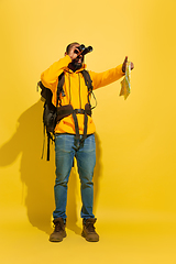 Image showing Full length portrait of a cheerful young african tourist guy isolated on yellow background