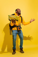 Image showing Full length portrait of a cheerful young african tourist guy isolated on yellow background