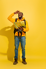 Image showing Full length portrait of a cheerful young african tourist guy isolated on yellow background