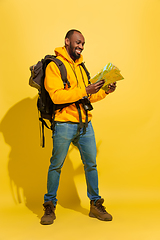 Image showing Full length portrait of a cheerful young african tourist guy isolated on yellow background