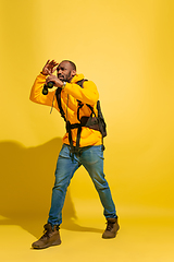 Image showing Full length portrait of a cheerful young african tourist guy isolated on yellow background