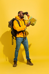 Image showing Full length portrait of a cheerful young african tourist guy isolated on yellow background