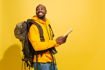 Image showing Full length portrait of a cheerful young african tourist guy isolated on yellow background