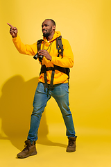 Image showing Full length portrait of a cheerful young african tourist guy isolated on yellow background