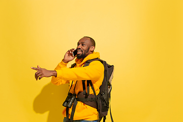 Image showing Full length portrait of a cheerful young african tourist guy isolated on yellow background