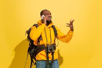 Image showing Full length portrait of a cheerful young african tourist guy isolated on yellow background