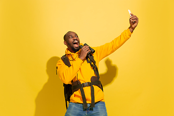 Image showing Full length portrait of a cheerful young african tourist guy isolated on yellow background