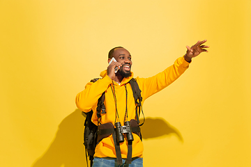 Image showing Full length portrait of a cheerful young african tourist guy isolated on yellow background