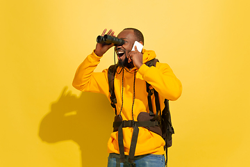 Image showing Full length portrait of a cheerful young african tourist guy isolated on yellow background