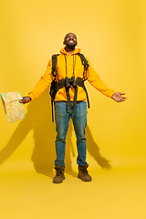 Image showing Full length portrait of a cheerful young african tourist guy isolated on yellow background