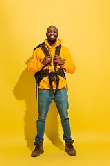 Image showing Full length portrait of a cheerful young african tourist guy isolated on yellow background