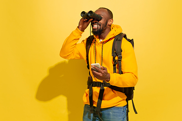 Image showing Full length portrait of a cheerful young african tourist guy isolated on yellow background