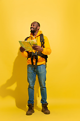 Image showing Full length portrait of a cheerful young african tourist guy isolated on yellow background