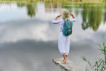 Image showing Young woman resting near lake