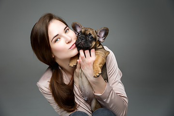 Image showing girl with french bulldog puppy