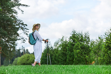 Image showing young woman with nordic walk pols