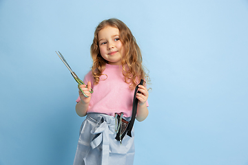 Image showing Little girl dreaming about future profession of seamstress