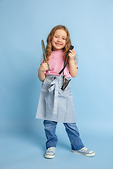 Image showing Little girl dreaming about future profession of seamstress