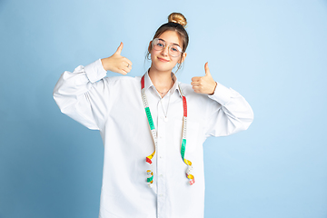 Image showing Young girl dreaming about future profession of seamstress