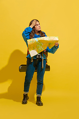 Image showing Full length portrait of a cheerful young caucasian tourist girl isolated on yellow background