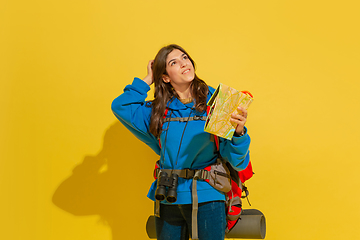 Image showing Full length portrait of a cheerful young caucasian tourist girl isolated on yellow background