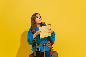 Image showing Full length portrait of a cheerful young caucasian tourist girl isolated on yellow background