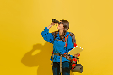 Image showing Full length portrait of a cheerful young caucasian tourist girl isolated on yellow background