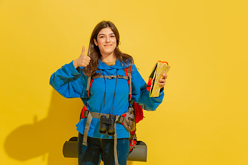 Image showing Full length portrait of a cheerful young caucasian tourist girl isolated on yellow background