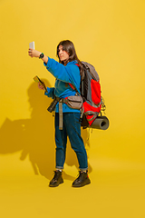 Image showing Full length portrait of a cheerful young caucasian tourist girl isolated on yellow background