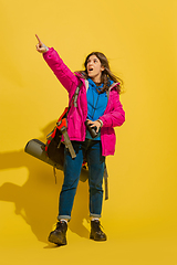 Image showing Full length portrait of a cheerful young caucasian tourist girl isolated on yellow background