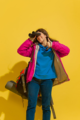 Image showing Full length portrait of a cheerful young caucasian tourist girl isolated on yellow background