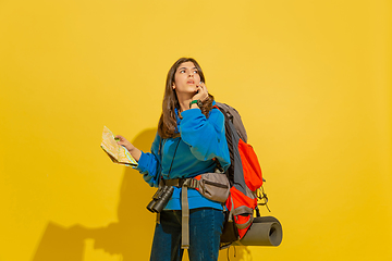 Image showing Full length portrait of a cheerful young caucasian tourist girl isolated on yellow background