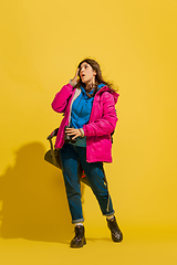 Image showing Full length portrait of a cheerful young caucasian tourist girl isolated on yellow background