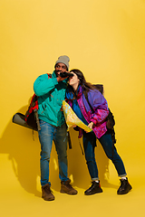 Image showing Portrait of a cheerful young tourist couple isolated on yellow background