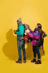 Image showing Portrait of a cheerful young tourist couple isolated on yellow background